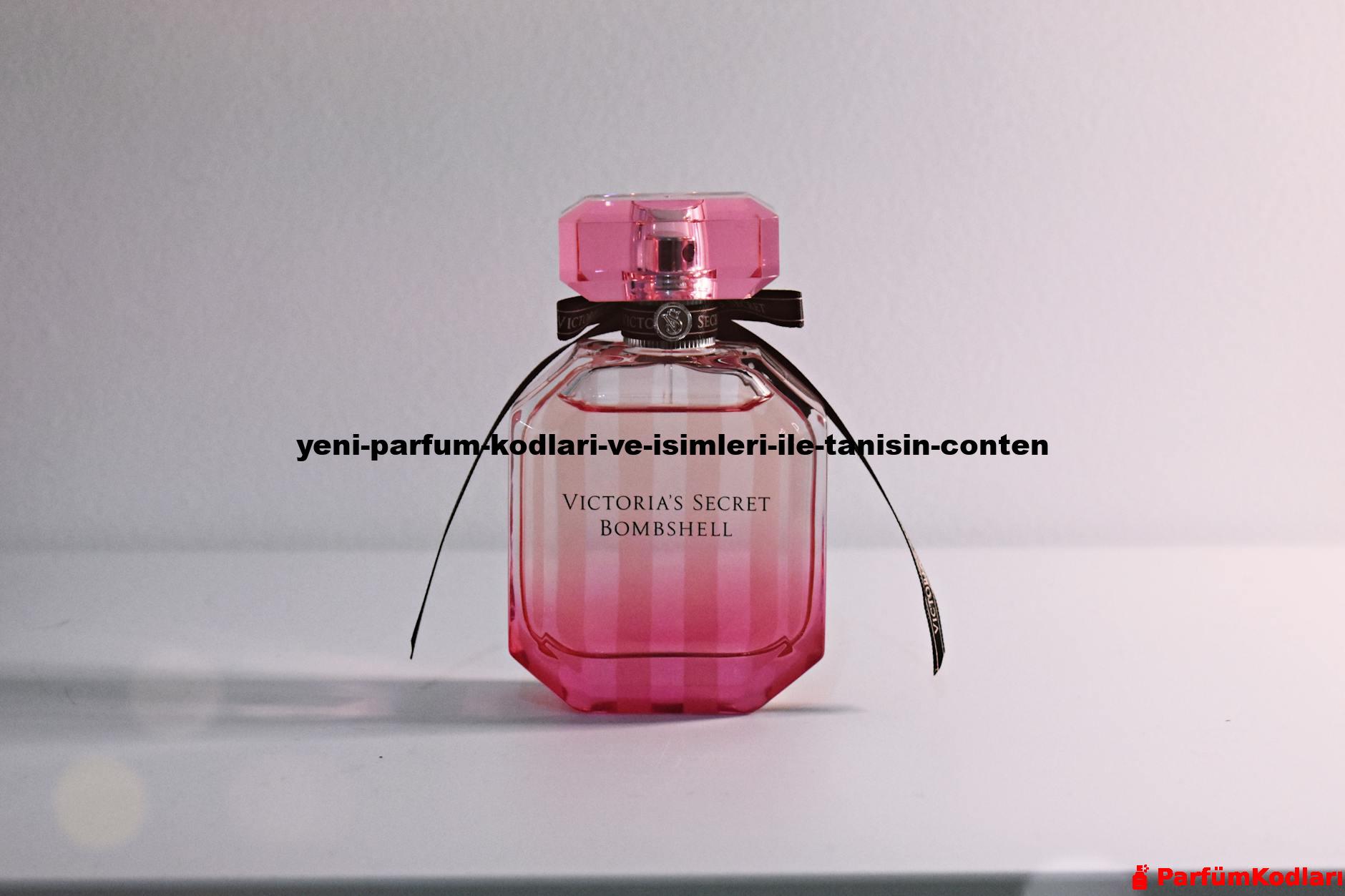 Stylish pink perfume bottle with bow and intricate cap on a white surface.