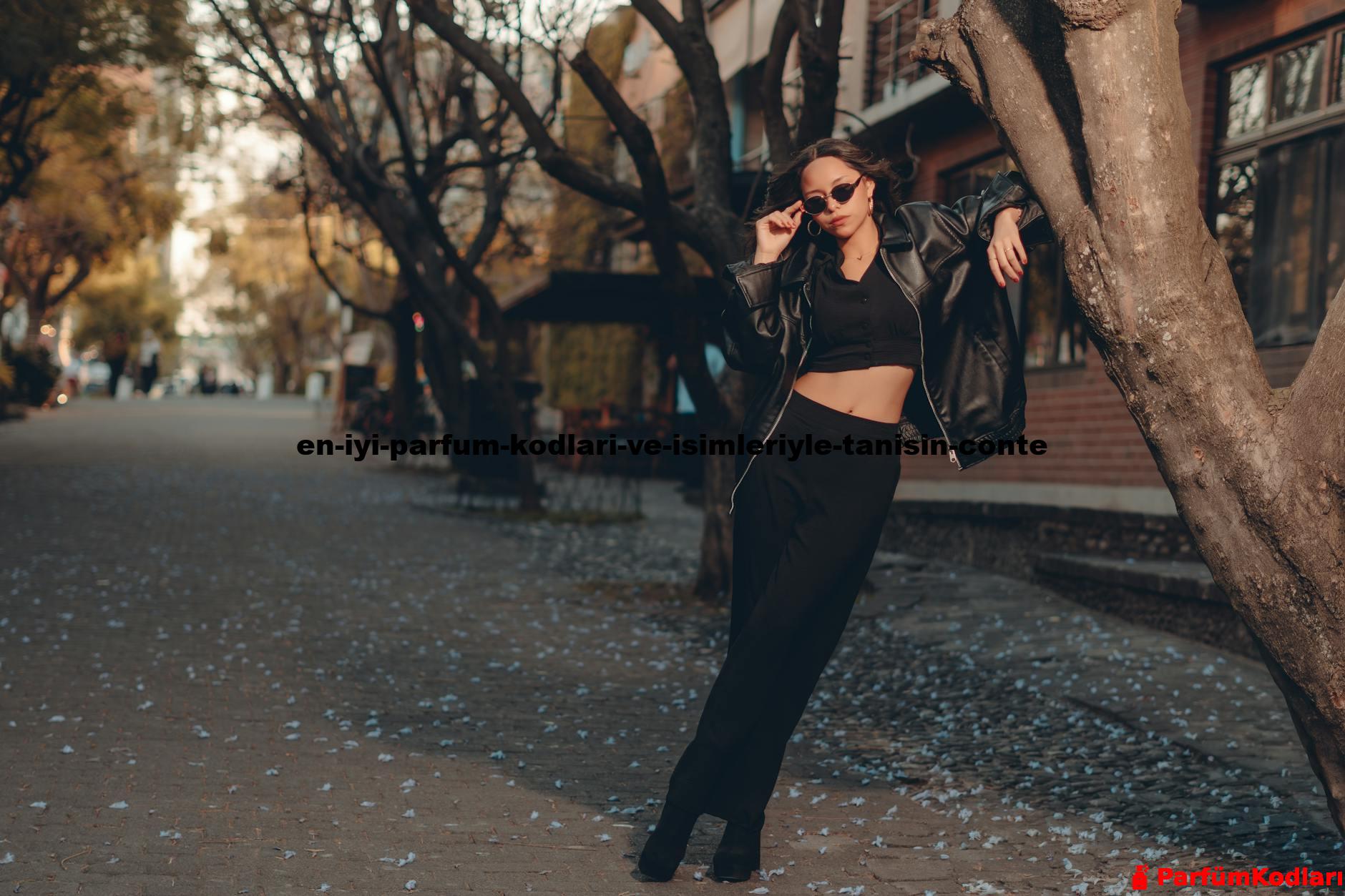 Stylish woman in black outfit poses in an urban autumn scene with scattered leaves.